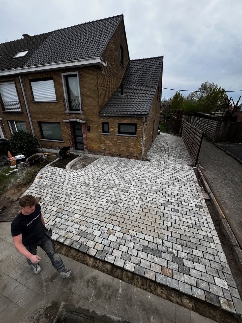 Kasseien leggen op een nieuw tuinpad naast de woning