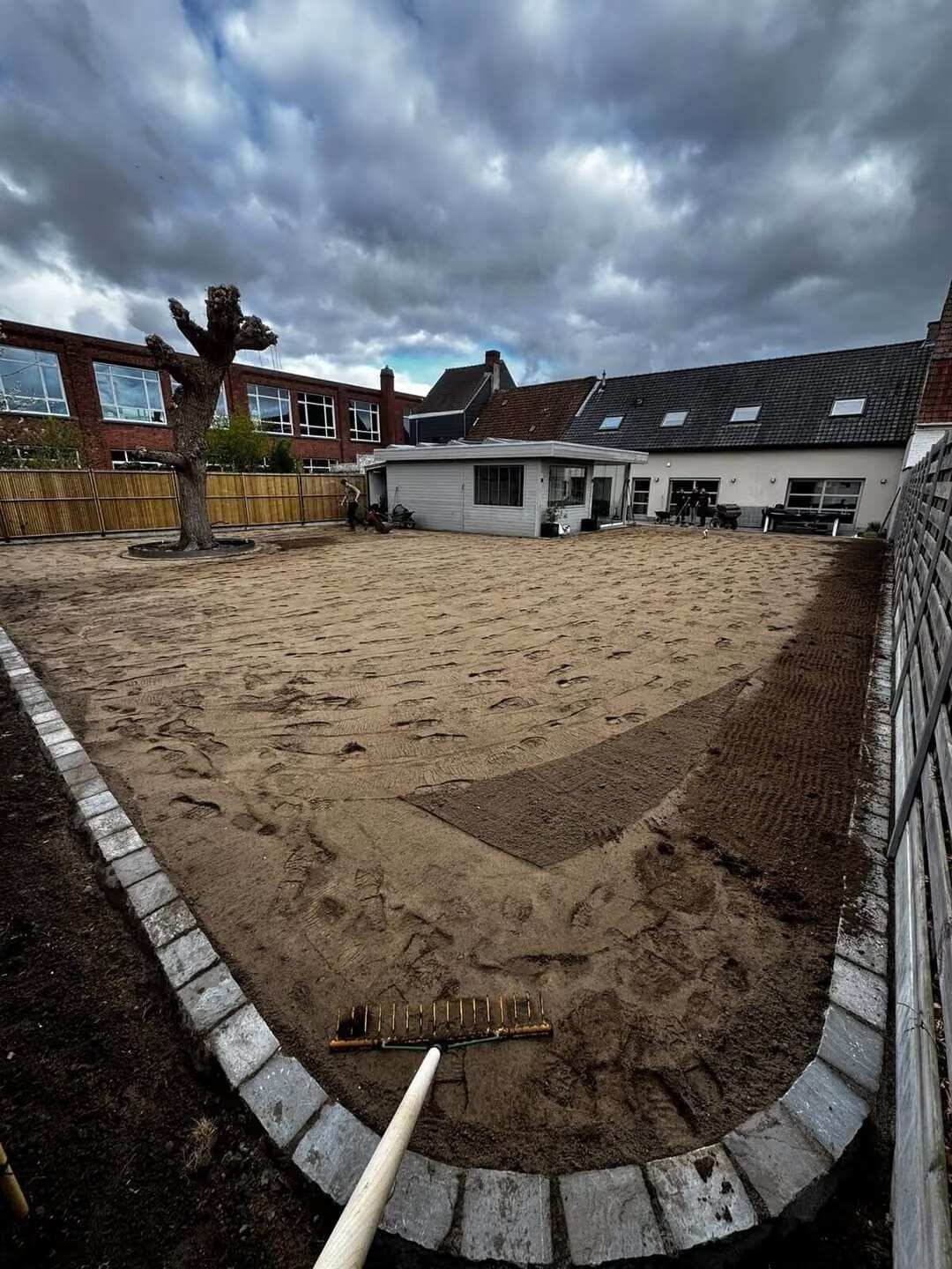 Geëgaliseerde tuin in zand, met kasseiboord en knotwilg, klaar voor de aanleg