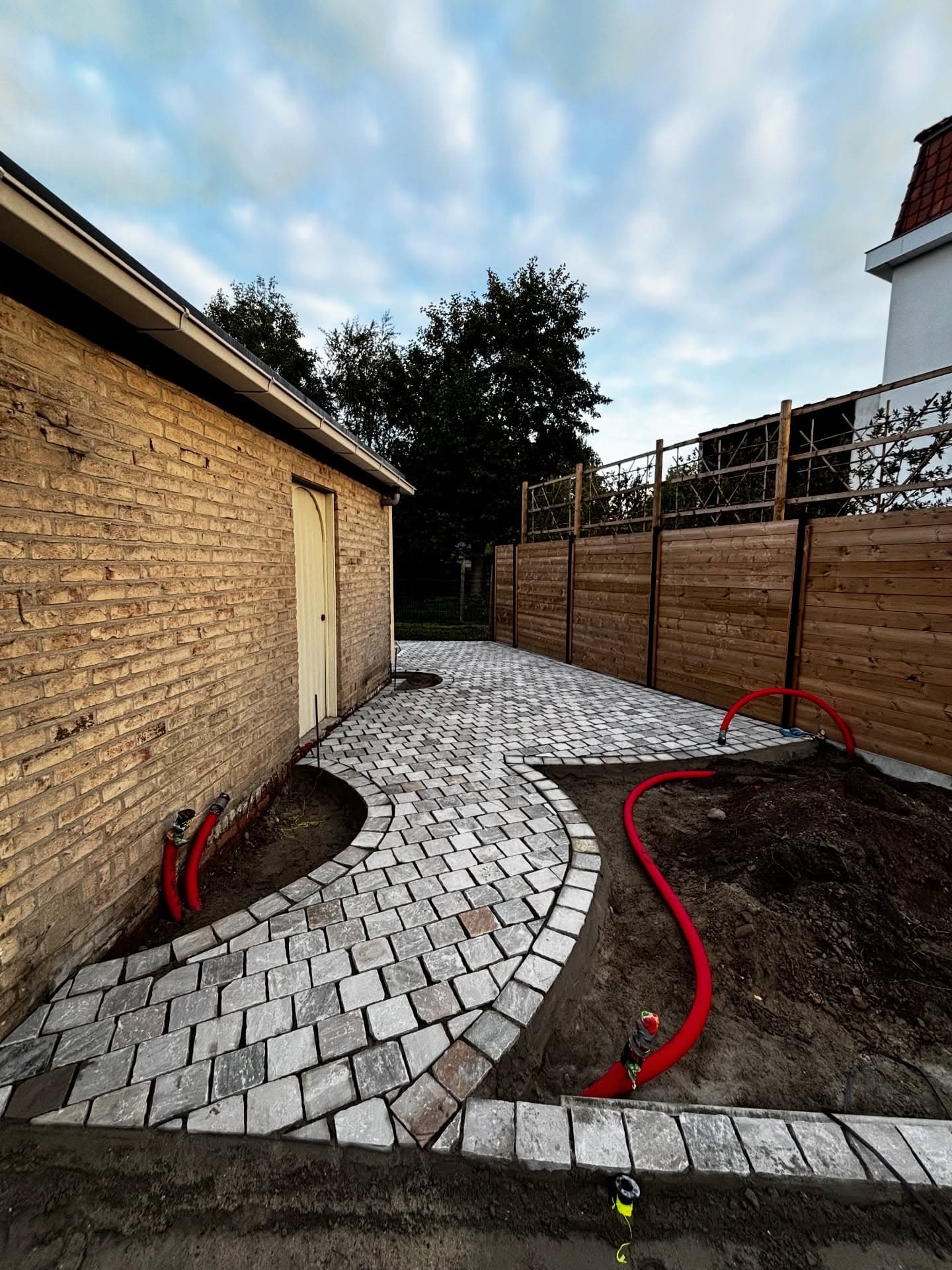 Gebogen tuinpad in kasseien naar de achtertuin