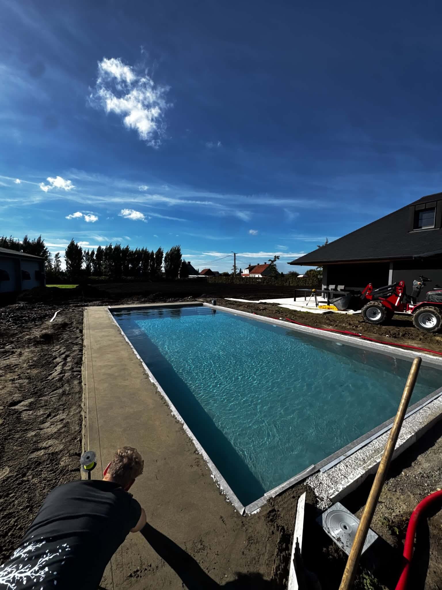 Nieuw zwembad met helder water, de tuin errond nog in aanleg